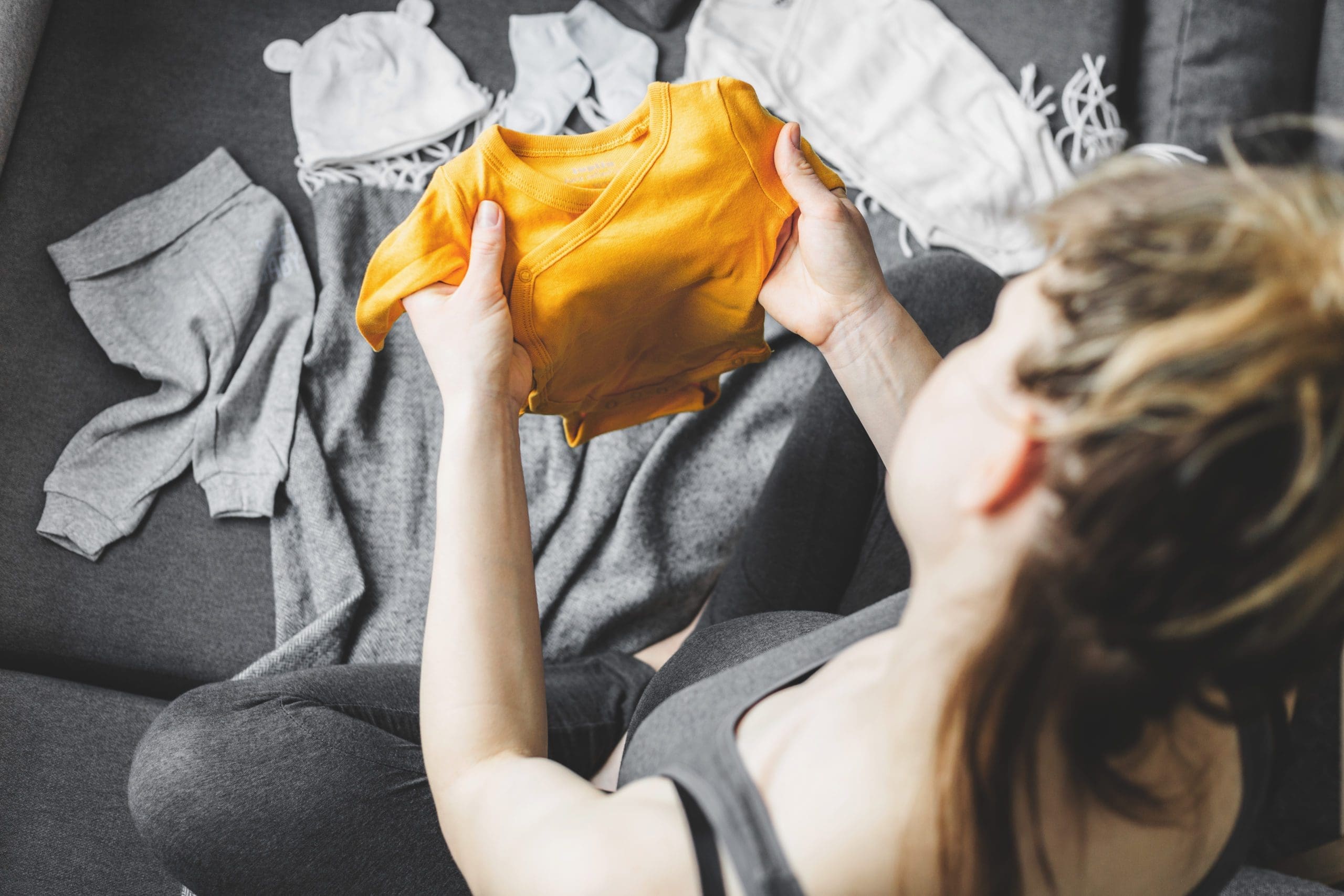 Young woman preparing clothes for baby