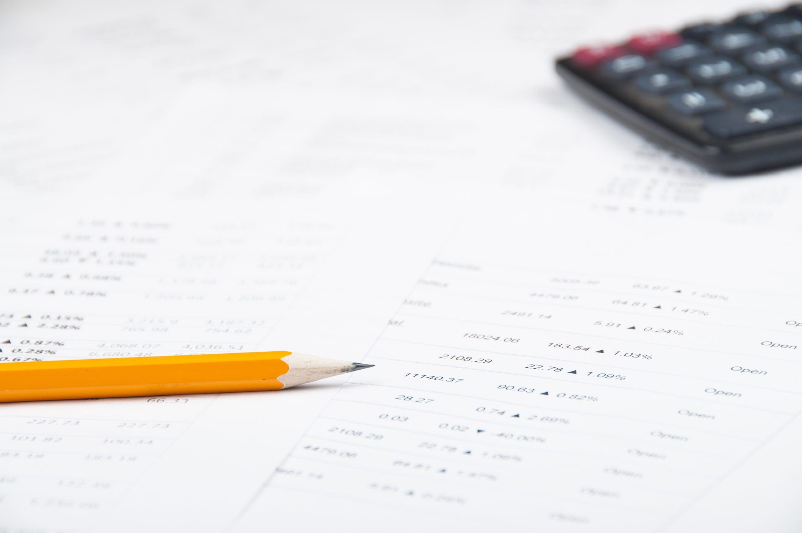 stock analysing on white printed paper yellow pencil and black calculator